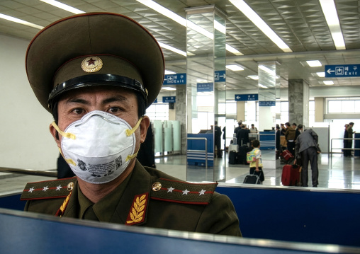 North Korean policeman wearing a face mask in Sunan international airport, DGC, Pyongyang, North Korea