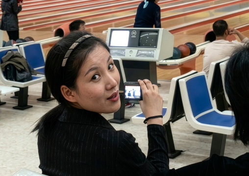 North Korean woman taking pictures at bowling, DGC, Pyongyang, North Korea