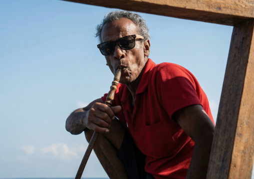 Portrait of a somali man smoking shisha on a dhow, Djibouti town, Gulf of Tadjoura, Djibouti