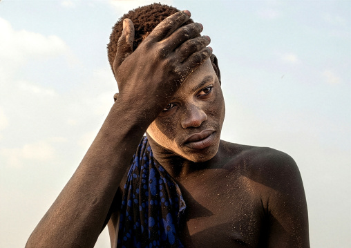 Mundari tribe boy putting ash on his body, Central Equatoria, Terekeka, South Sudan