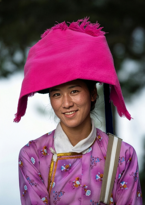 Smiling Mosuo woman with pink headwear, Lugu Lake, Yunnan Province, China