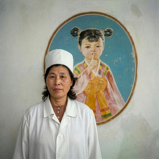 Nurse in front of a poster telling the children to be silent, DGC, Pyongyang, North Korea