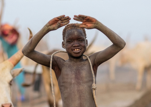 A Mundari tribe boy mimics the position of horns of his favourite cow, Central Equatoria, Terekeka, South Sudan