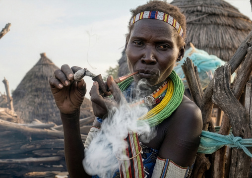 Toposa tribe woman smoking pipe in a village, Namorunyang State, Kapoeta, South Sudan