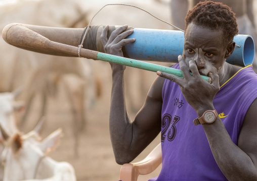Mundari tribe man blowing in a cow horn, Central Equatoria, Terekeka, South Sudan