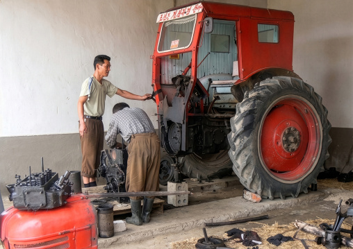 Men fixing an old tractor, South Hamgyong Province, Hamhung, North Korea