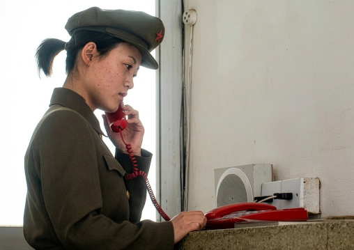 North Korean woman guard on the phone in a museum, DGC, Pyongyang, North Korea