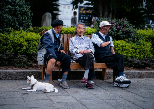 Naxi old people stiting on a bench, Lijiang, Yunnan Province, China