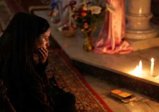 Eritrean woman praying in a church lit by candles, Central Region, Asmara, Eritrea