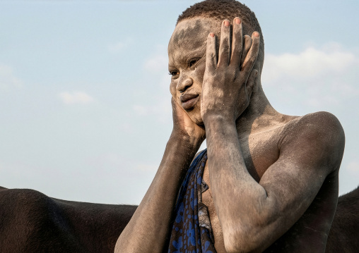 Mundari tribe man covering his body in ash to repel flies and mosquitoes, Central Equatoria, Terekeka, South Sudan