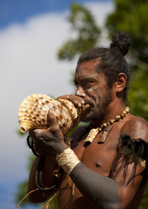 Warrior blowing in a shell during carnival in Tapati festival, Easter Island, Hanga Roa, Chile
