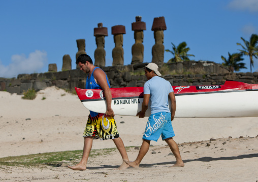 Men carrying a pirogue in front of ahu nau nau at anakena beach, Easter Island, Hanga Roa, Chile
