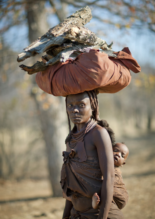 Muhimba Woman With Her Baby On Her Back Carrying Wood On Her Head, Village Of Elola, Angola