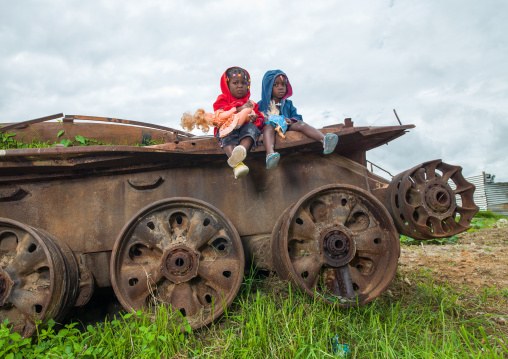 Angolan children playing on a tank wreck, Huambo Province, Huambo, Angola