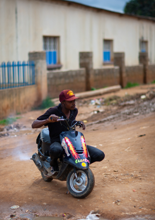 Angolan young man driving a scooter in the street, Huambo Province, Huambo, Angola