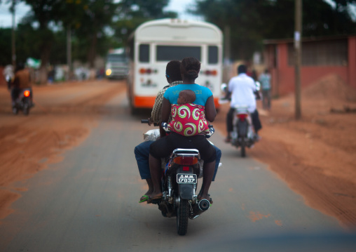 Angolan family riding a motorcycle on the road, Malanje Province, Malanje, Angola