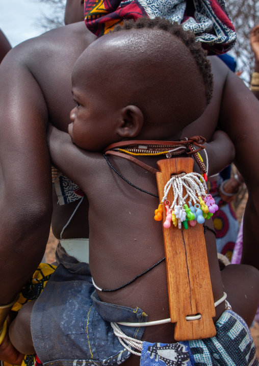 Mucubal tribe woman with her child wearing an ombeleketha talisman on the back to protect him, Namibe Province, Virei, Angola