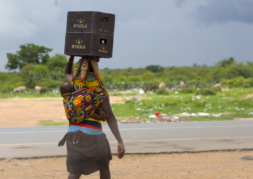 Mwila Woman Carrying Beer Crates On Her Head And A Baby On Her Back, Chibia Area, Angola