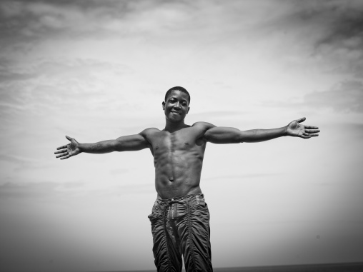 Man Doing The Christian Cross With His Arms On The Beach, Benguela, Angola