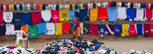 Woman Passing By Clothes In A Street Market, Benguela, Angola