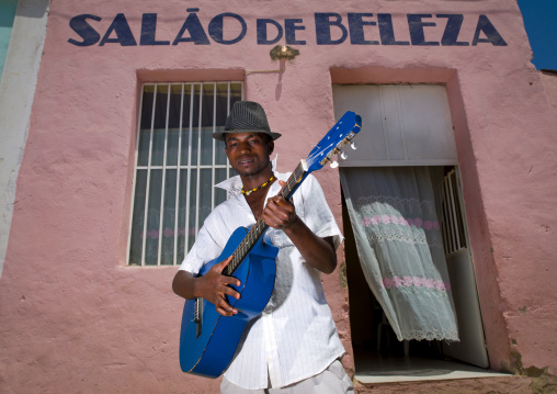 Man With Hat Playing Guitar In Front Of A Beauty Salon, Angola