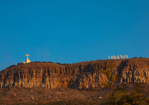 Cristo Rei christ near a giant billboard of lubango in the hollywood style on the top of a hill, Huila Province, Lubango, Angola