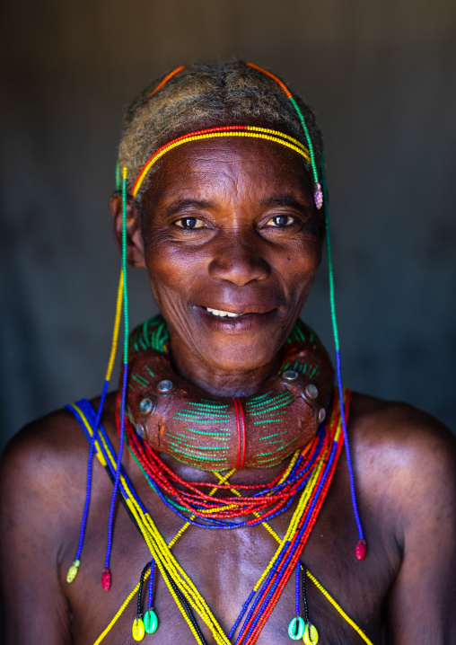 Smiling mungambue tribe woman with the traditional hairtsyle and necklace, Huila Province, Chibia, Angola