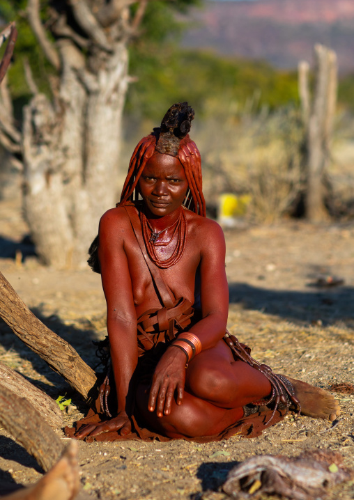 Himba tribe woman sit near her hut, Cunene Province, Oncocua, Angola