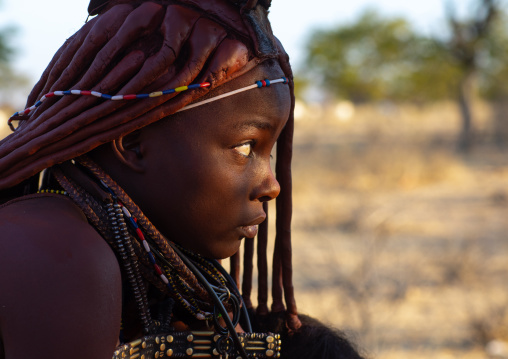Himba tribe woman with a ray of light on her face, Cunene Province, Oncocua, Angola