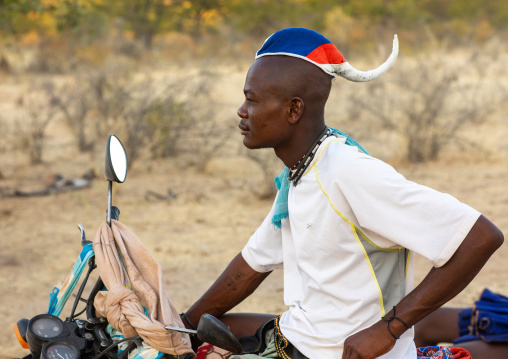 Himba tribe single man with his motorbike, Cunene Province, Oncocua, Angola