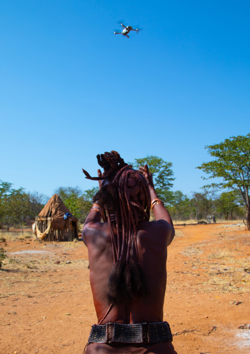 Batwa tribe old woman looking at a drone in the sky, Cunene Province, Oncocua, Angola