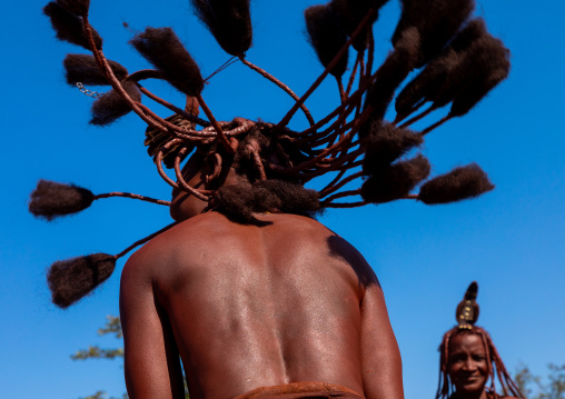 Batwa tribe woman dancing and playing with her dreadlocks, Cunene Province, Oncocua, Angola