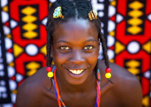 Portrait of a mudimba tribe woman in front of a colorful printed cloth, Cunene Province, Cahama, Angola