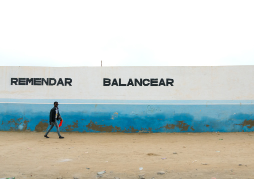 Angolan man passing in front of a garage wall, Namibe Province, Namibe, Angola