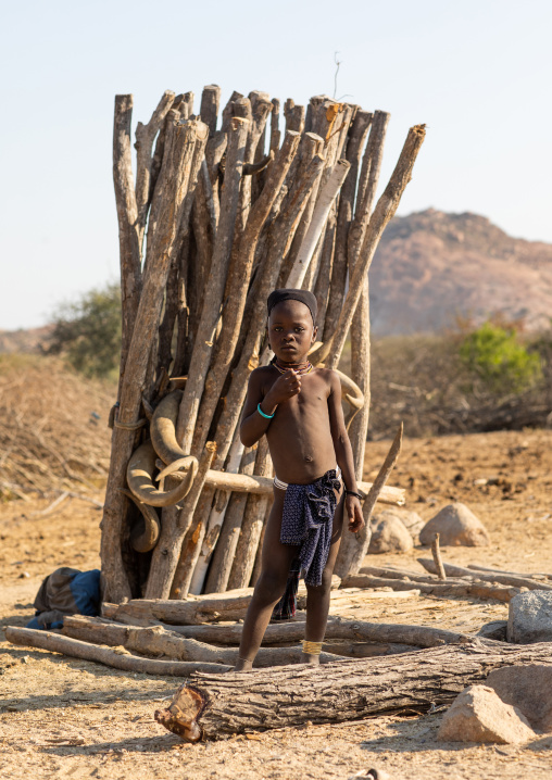 Mucubal tribe girl in front of a totem with cow horns, Namibe Province, Virei, Angola