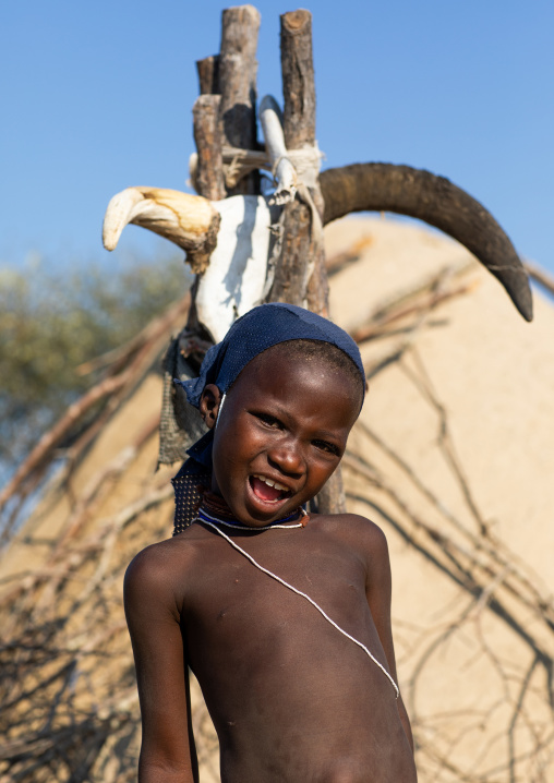 Mucubal tribe girl in front of a totem with cow horns, Namibe Province, Virei, Angola