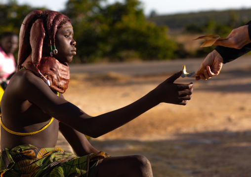 Mumuhuila tribe woman receiving money from a tourist who took pictures of her, Huila Province, Lubango, Angola
