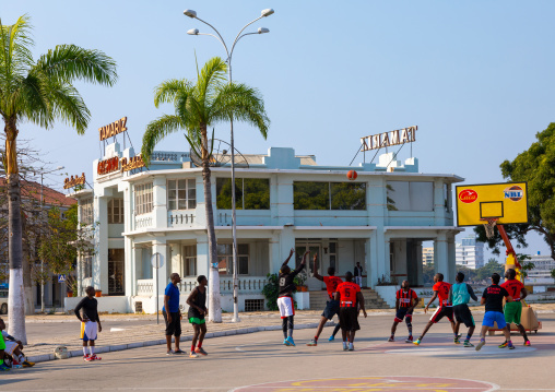 Angolan men playing basket ball in front of the old portuguese colonial tamariz casino, Benguela Province, Lobito, Angola