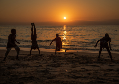 Boys dancing capoeira on the beach at sunset, Benguela Province, Benguela, Angola