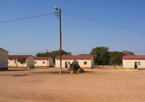 Children pumping water in front of middle class new houses, Cunene Province, Oncocua, Angola