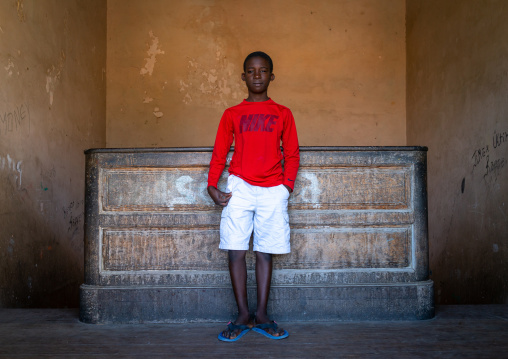 Angolan boy with a red Nike shirt in a house, Namibe Province, Namibe, Angola