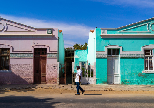 Angolan man walking in front of old portuguese colonial houses, Namibe Province, Namibe, Angola