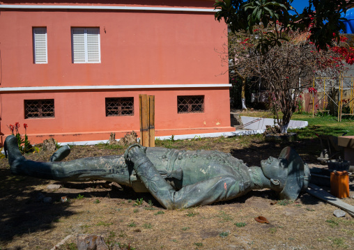 Old bronze portuguese statue laying down on the grass, Huila Province, Lubango, Angola