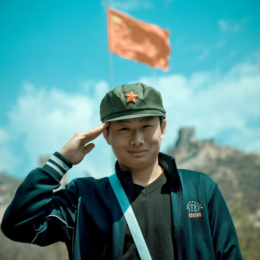 Young Man Saluting In Front Of The Great Wall, Beijing, China