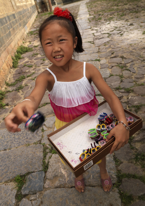 Girl Selling Little Feet Shoes For Tourists, Tuan Shan Village, Yunnan Province, China