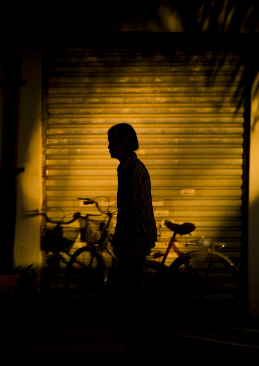 Silhouette Of A Woman In The Street, Menglun, Yunnan Province, China