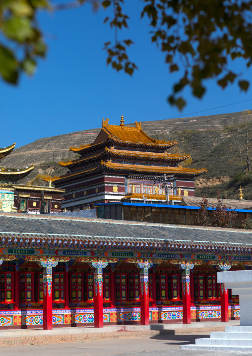 Buddhist temples and beautifully painted prayer wheels in Wutun si monastery, Qinghai province, Wutun, China
