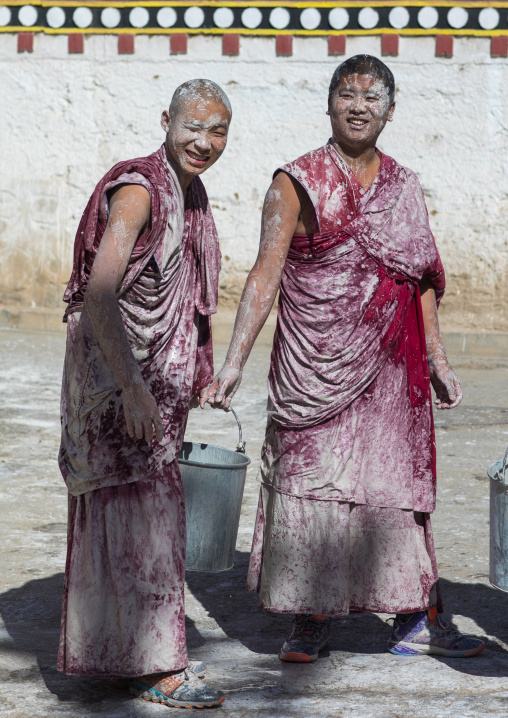 Tibetan monks enjoying a water fight after the yearly renovation of the Rongwo monastery, Tongren County, Longwu, China