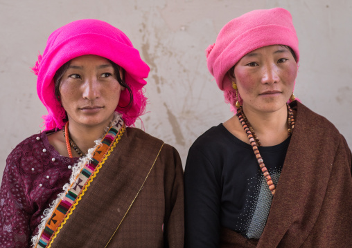 Portrait of tibetan nomads women with a pink headwears, Qinghai province, Tsekhog, China