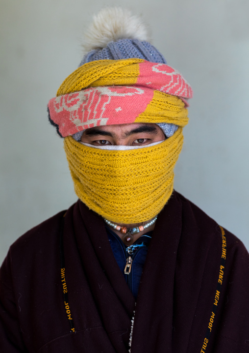 Portrait of a tibetan nomad man protecting his face from the cold, Qinghai province, Tsekhog, China